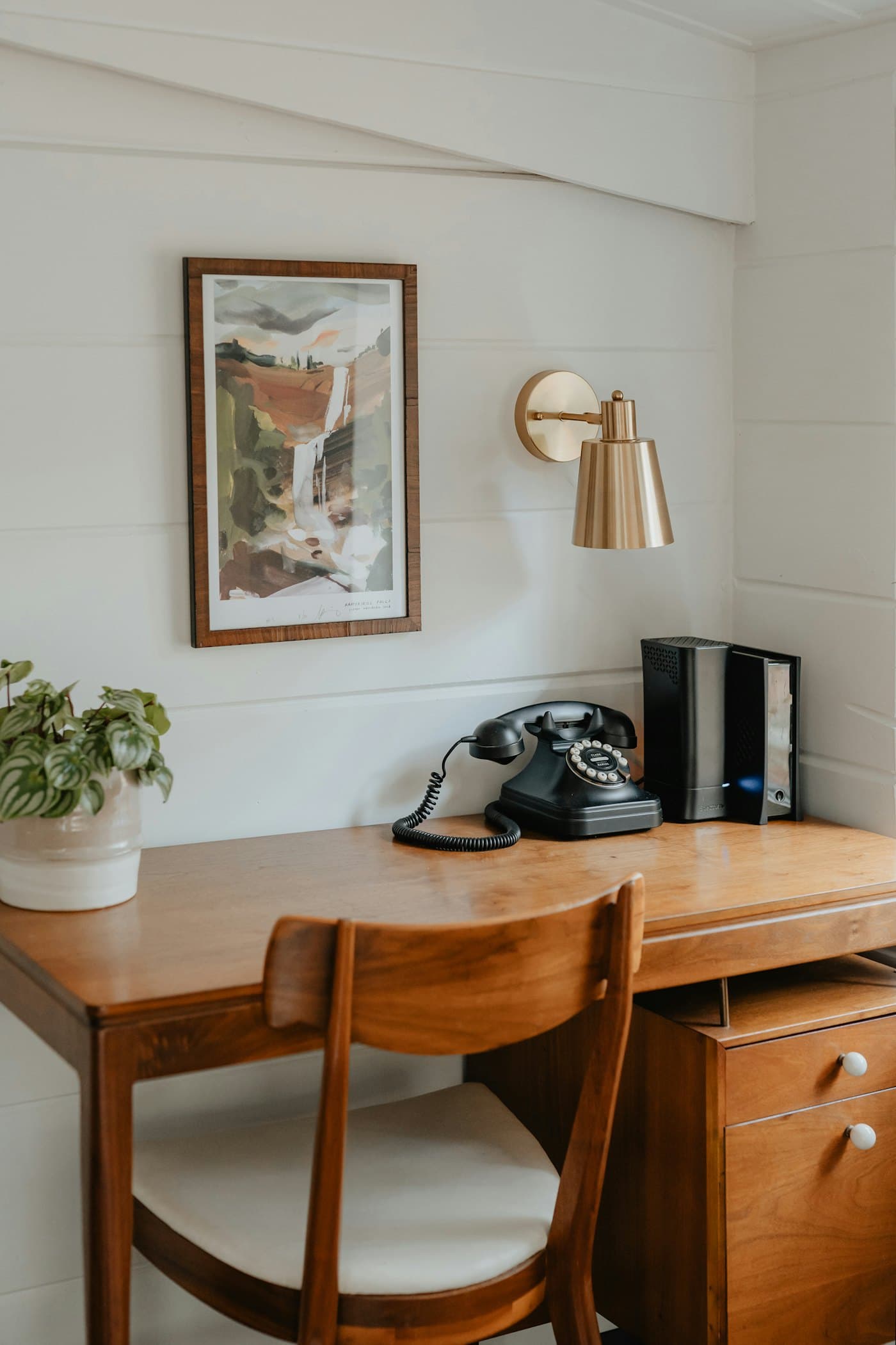 Un téléphone sur un bureau en bois, près d’une plante