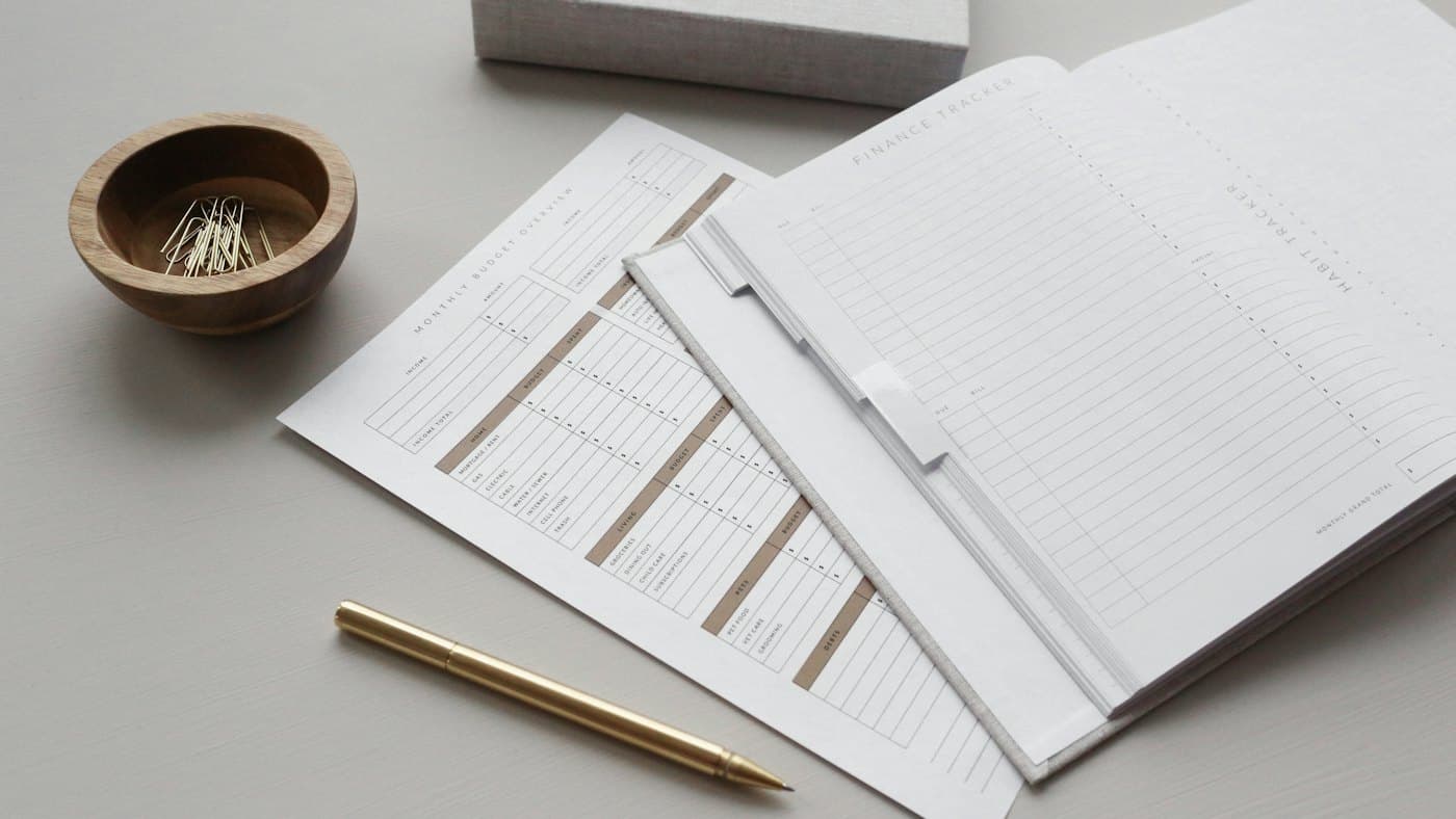 Des feuilles de budget et un carnet de suivi financier sur un bureau